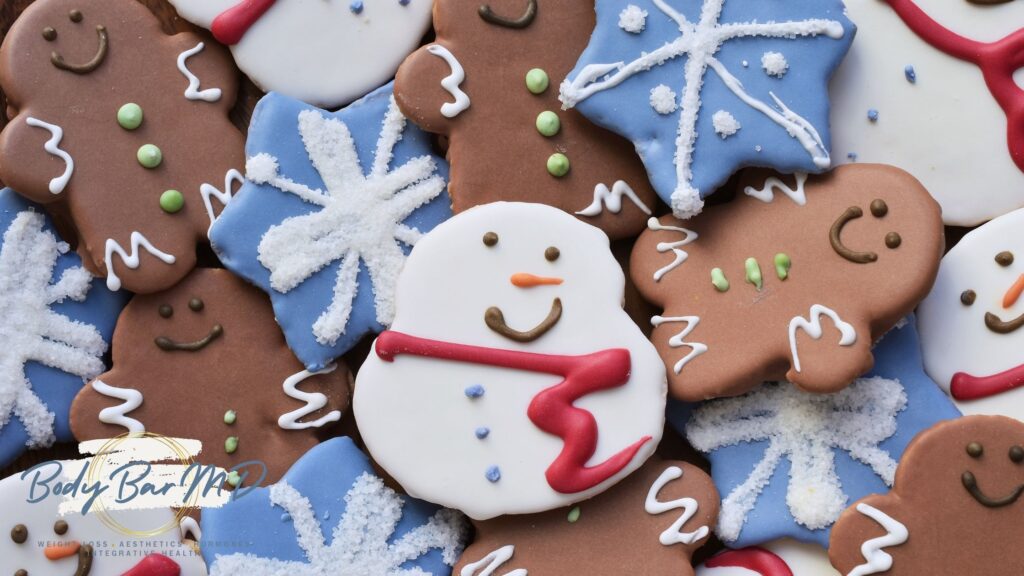 Festive holiday cookies, including snowmen and gingerbread, symbolizing holiday indulgence with Body Bar MD branding.