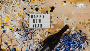 A celebratory New Year scene with a "Happy New Year" sign, confetti, a disco ball, and a champagne bottle.