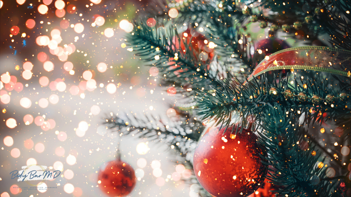 A beautifully decorated Christmas tree with glowing red ornaments and festive ribbon, surrounded by sparkling holiday lights.