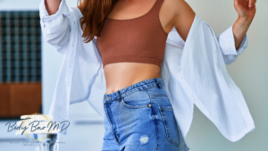 Close-up of a woman in a cropped top and jeans with a white shirt, symbolizing confidence and vitality.