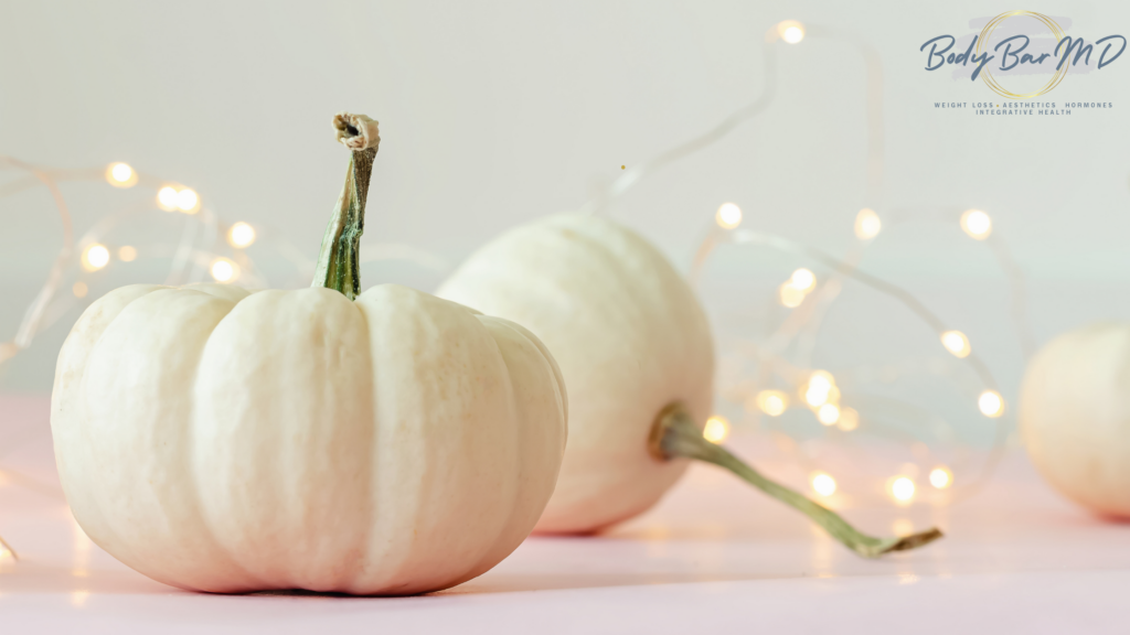 White pumpkins with string lights in the background, embodying a serene, festive atmosphere for Thanksgiving