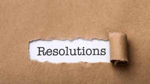 A torn piece of brown paper revealing the word "Resolutions," symbolizing the importance of achieving health goals.