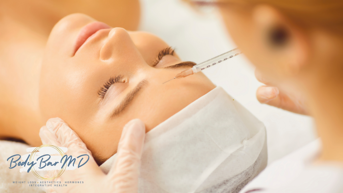 Close-up of a woman receiving a Botox injection on her forehead, highlighting advanced aesthetic treatments at Body Bar MD.