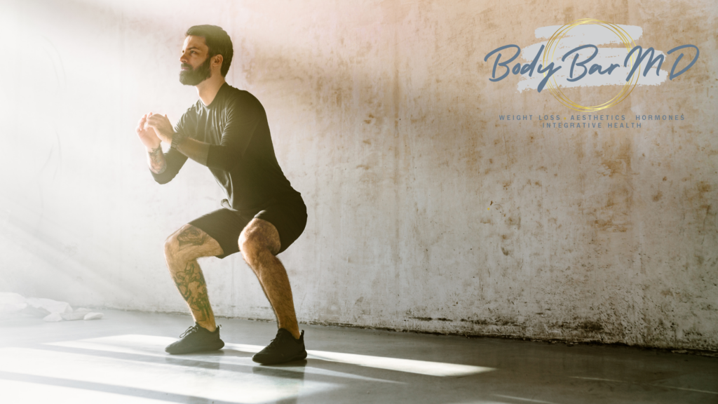 Man performing a squat exercise in a well-lit room, symbolizing strength, wellness, and a healthy lifestyle with Body Bar MD’s logo in the background. Approach at Body Bar MD