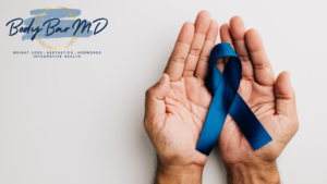 Hands holding a blue awareness ribbon, symbolizing support for health awareness and prevention. The Body Bar MD logo appears on the left side, highlighting a focus on weight loss, aesthetics, hormones, and integrative health.