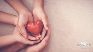 Hands of an adult and child gently holding a red heart symbol, representing love, care, and heart health. The Body Bar MD logo is visible in the bottom right corner.