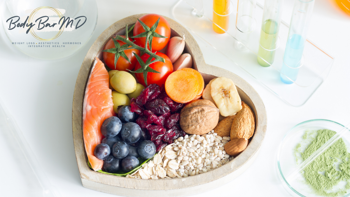 Heart-shaped bowl filled with healthy foods like salmon, blueberries, tomatoes, and nuts, symbolizing heart health and nutrition.