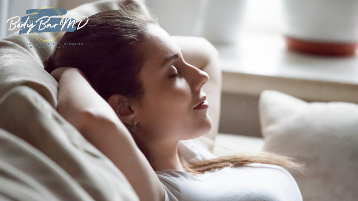 A relaxed woman resting on a couch with her eyes closed, enjoying a moment of peace and tranquility.